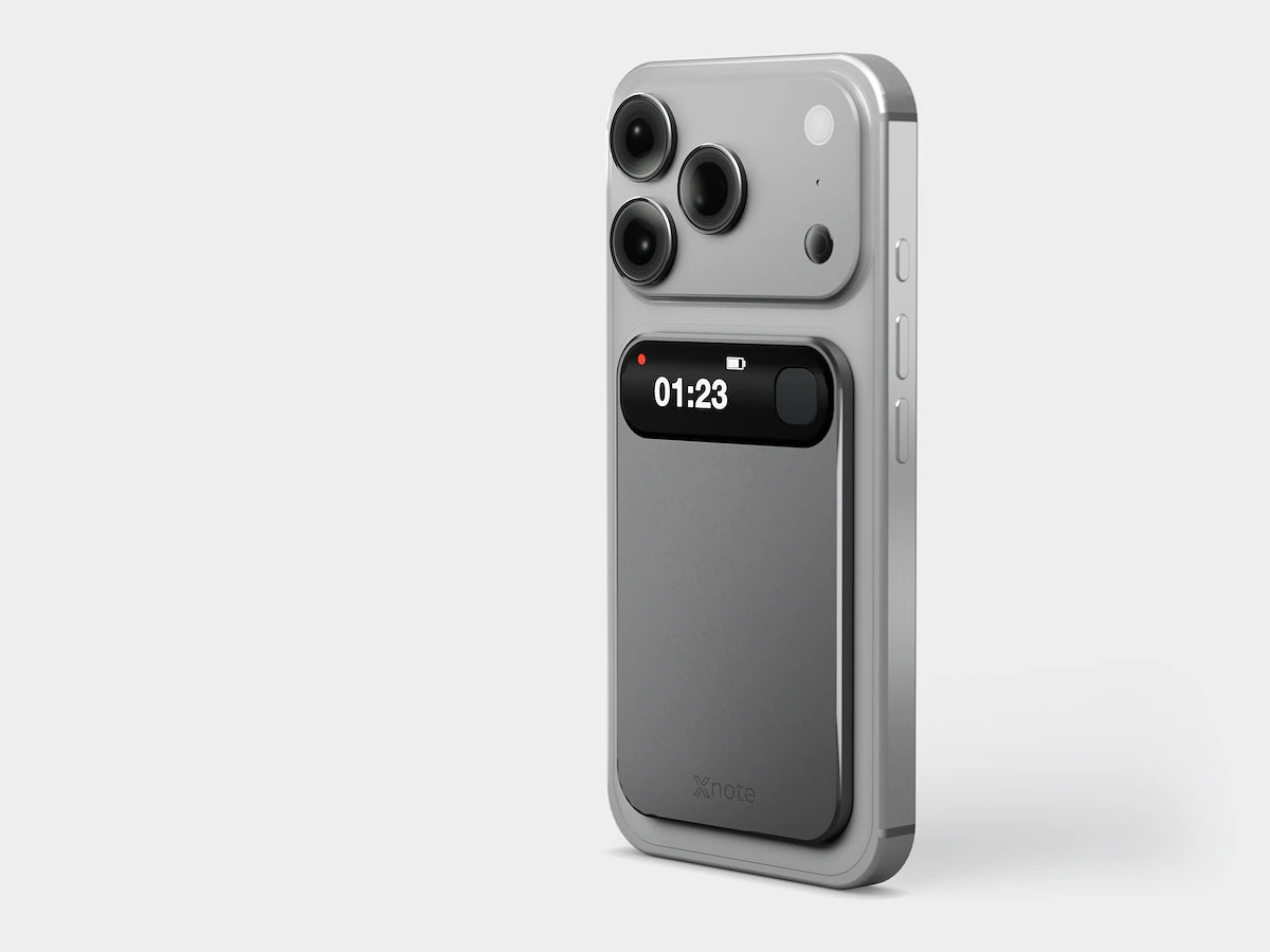 Pre-production XNote Voice on the back of a phone, display showing a red dot and 01:23. Phone not included.